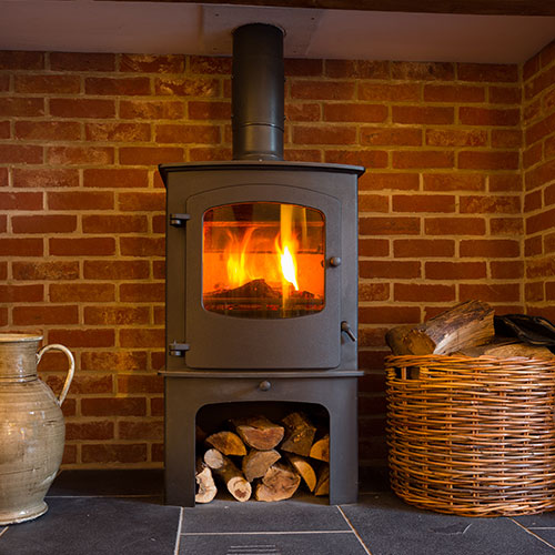 Wood Stove Installations-Wood below the stove with basket of wood on the right-Rutland Chimney
