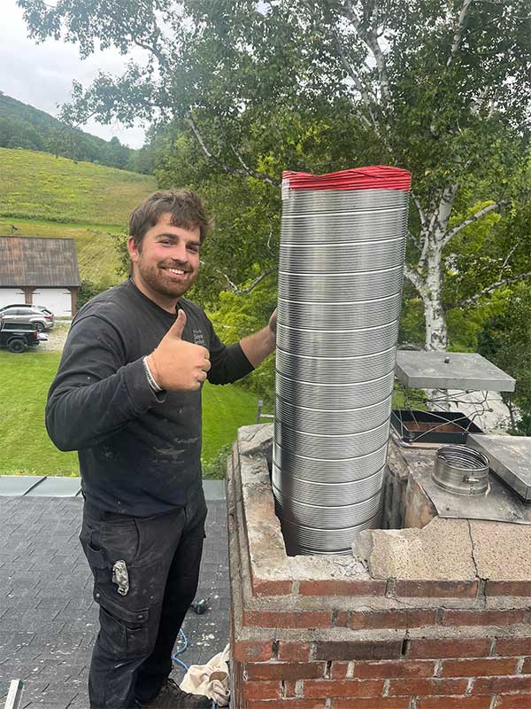 Stainless Steel Liner Install with tech doing a thumbs up and farmland in background - original image - Rutland Chimney